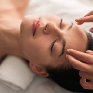 gros plan sur la tête du massé et les mains du masseur
